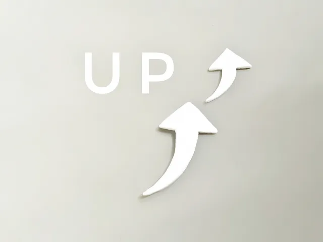 「UP」の文字と、上向きに伸びる2本の白い矢印