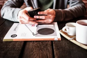 スマートフォンを操作する手元とコーヒーカップ
