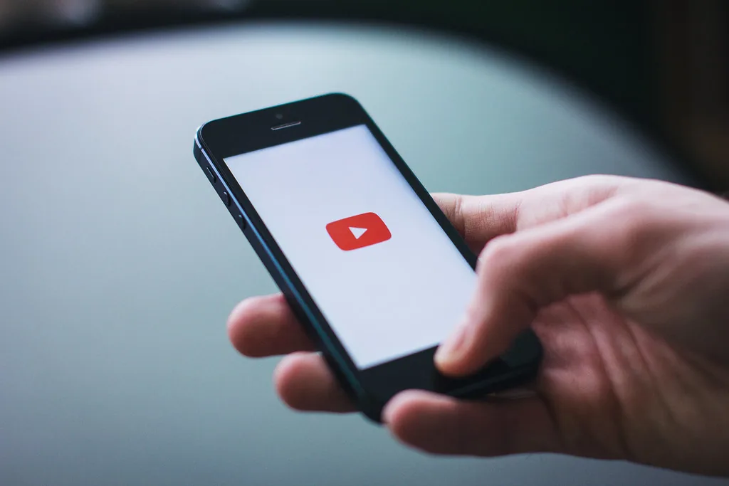 YouTubeアプリを開いたスマートフォンを持つ手元